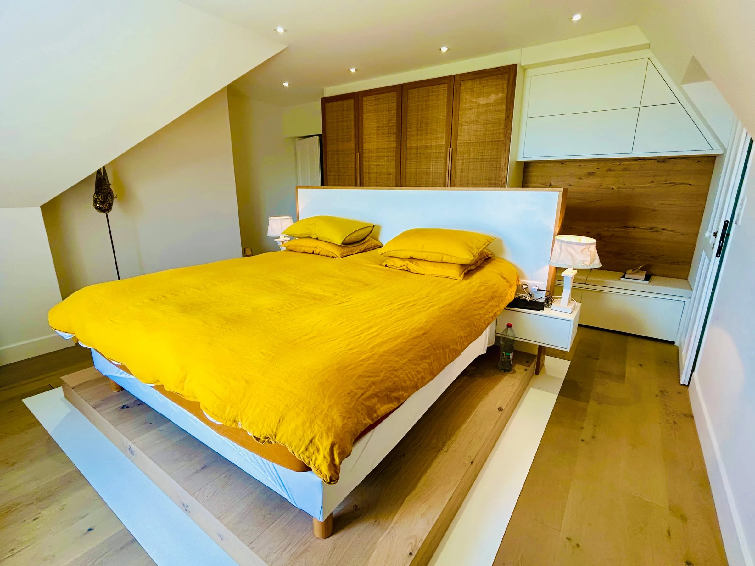 Chambre sous combles, linge jaune et rangements en bois