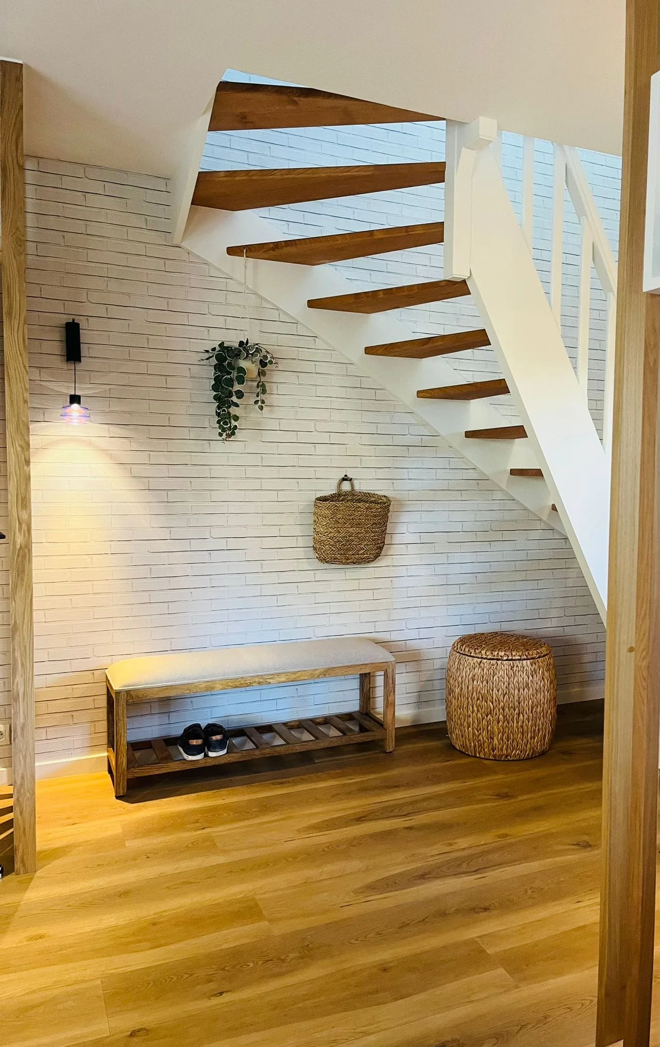 Escalier suspendu et mur de briques blanches