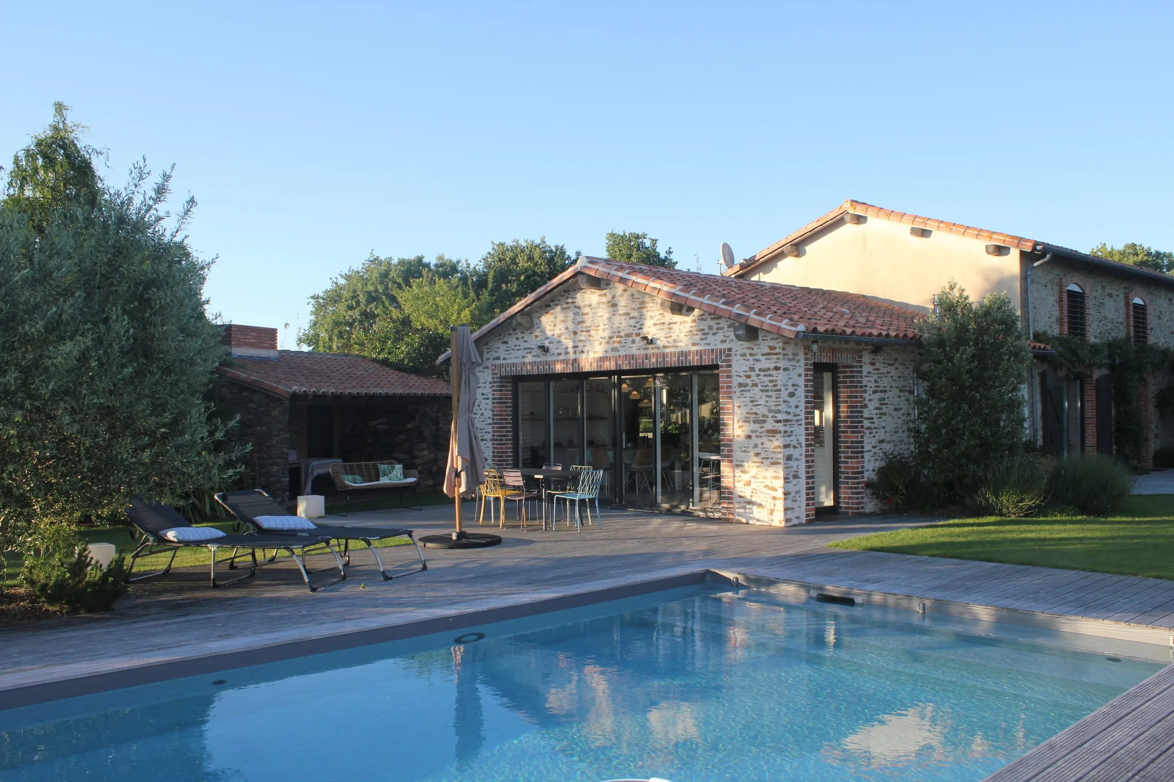 Bâtiment en pierre et piscine dans le jardin