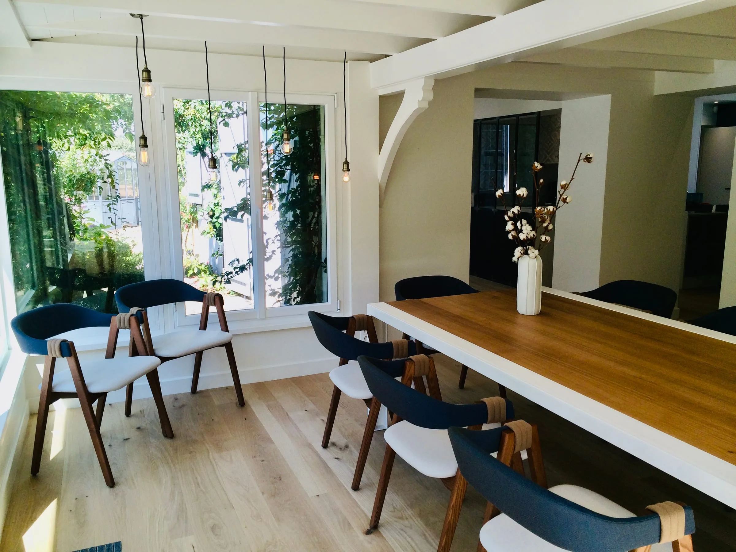 Salle à manger lumineuse, table en bois et chaises bleues