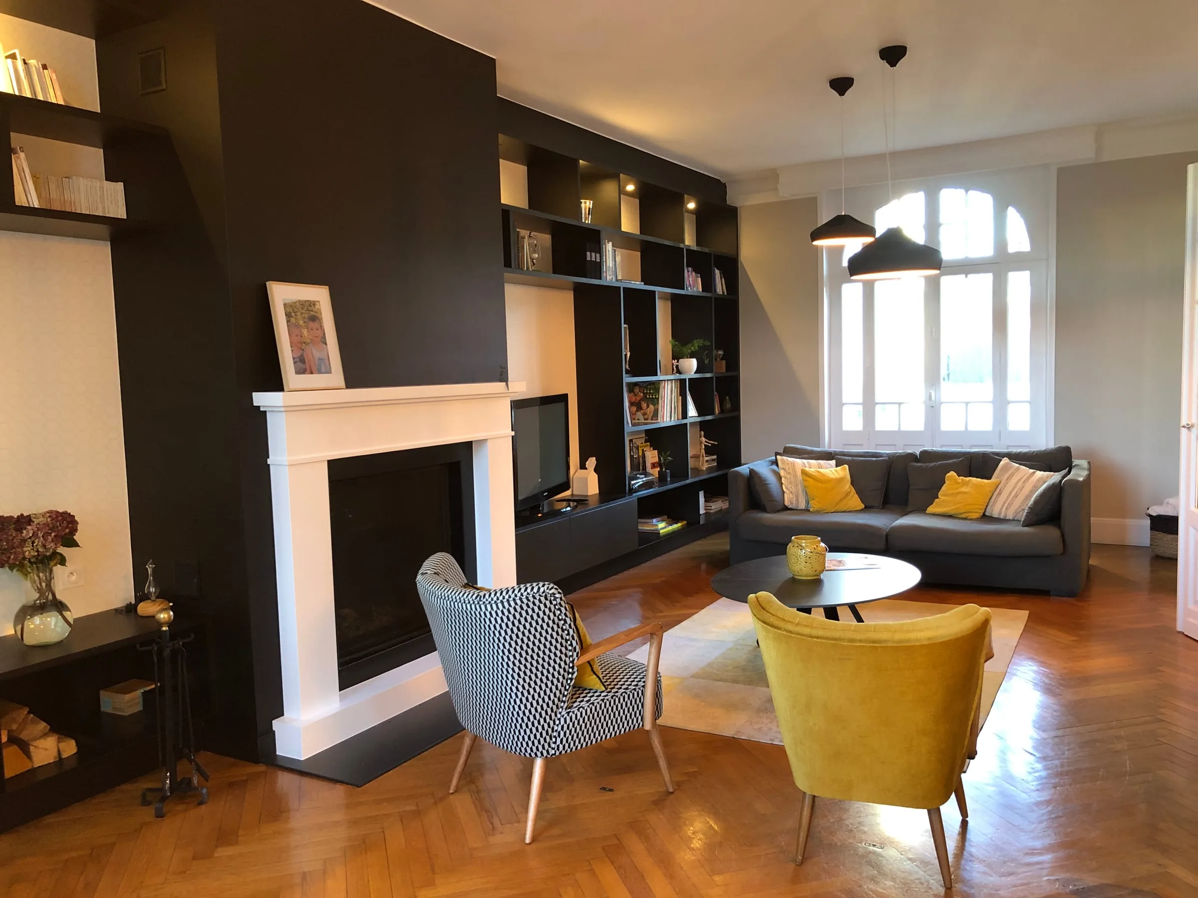 Salon avec bibliothèque murale et fauteuils colorés