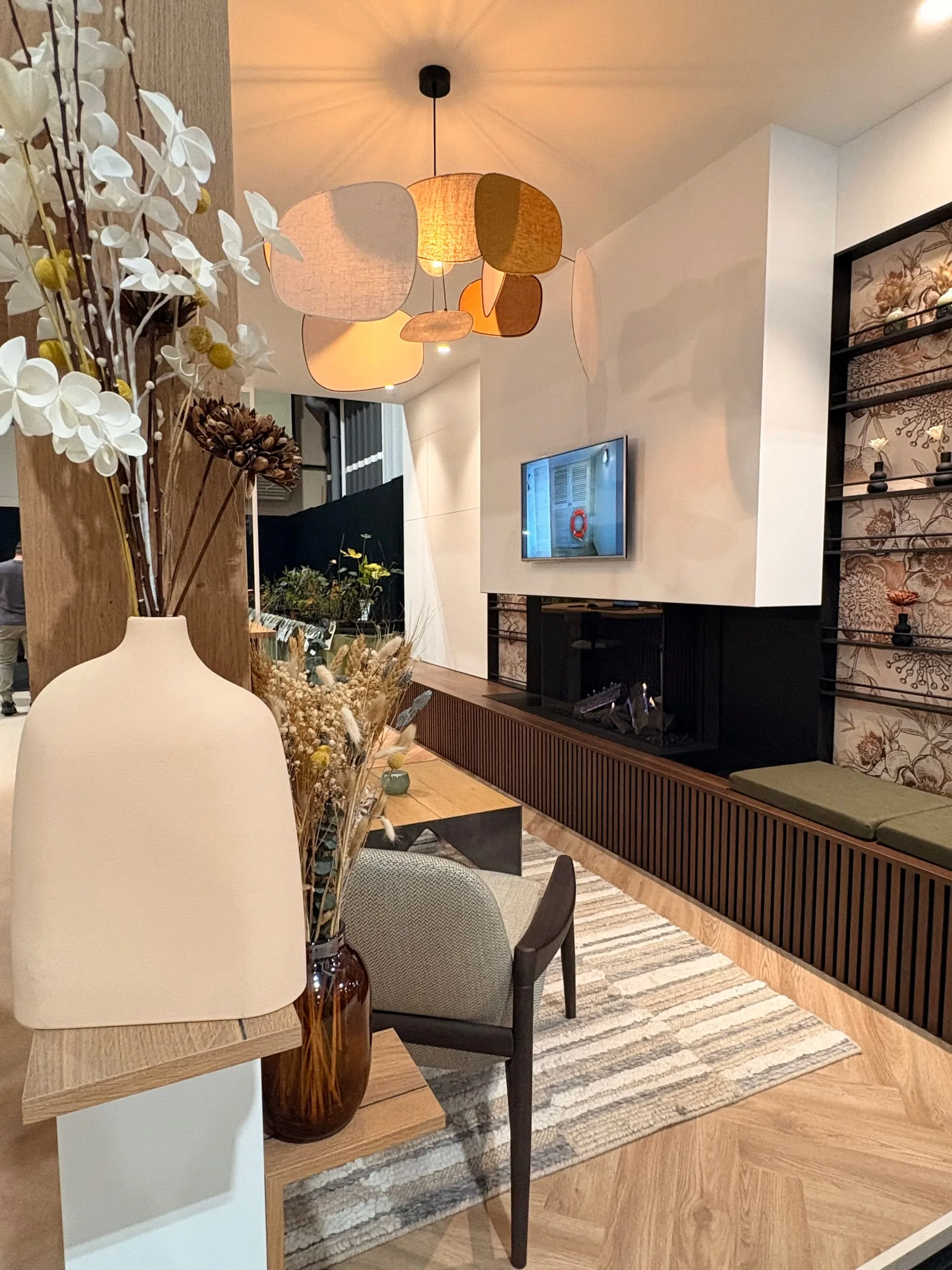 Salon chaleureux, suspensions en tissu et meuble en bois sombre