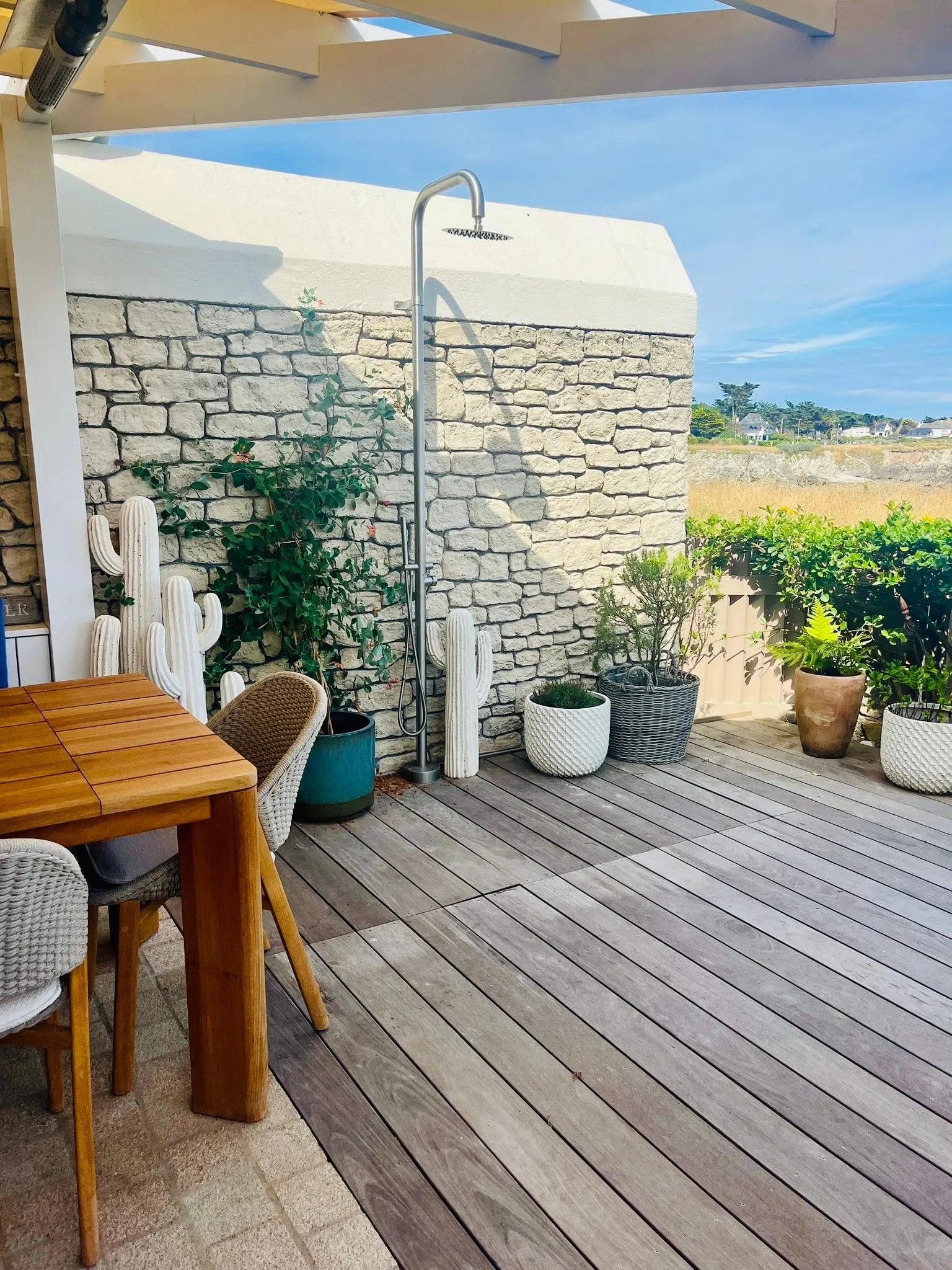 Terrasse en bois avec plantes et mur de pierre