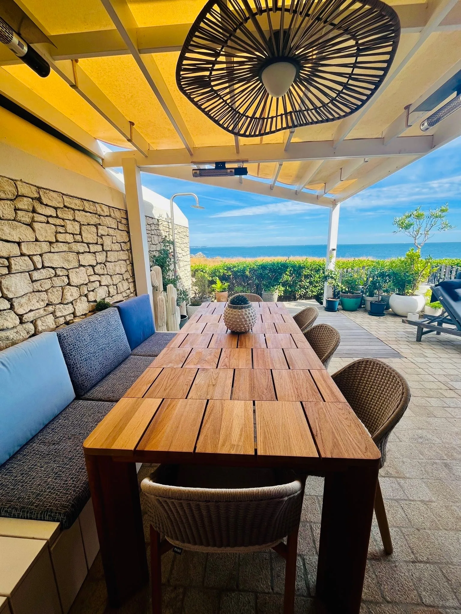 Terrasse couverte et grande table face à la mer